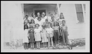 Carlingford School circa 1950-51. This photo was taken by Jerry’s Mother, Beulah “Boots” Smyth, who was the teacher at the school for several years. Can anyone identify the kids?  Naomi Brown is 3rd from the left in the front row, and Gladys Cole is 2nd from the right in the front row. Jerry says there are a number of Clarks & Gamblins in the photo as well.