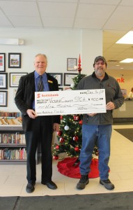 Perth-Andover ScotiaBank branch manager  Mike Allen and SPCA volunteer Bill Mosher with the Fur Tree cheque. See those books  behind Mike? This eclectic selection of books are for sale by donation to raise funds for other worthy causes...check them out!