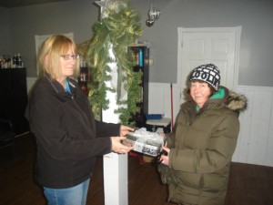 The 2013 SPCA Fur Tree winner Karen Elliot is thrilled to receive the  box full of gift certificates from Libby Mosher!
