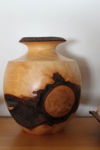 This  elegant vase is turned from a single  large burl… the circle on the side was the tree branch