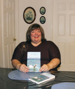 Kate Williams displays copies of her recently   published book “Diving Deep Into Faith”