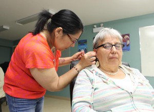 Alison is gently inserting the acupuncture needles into Sharlene’s ear