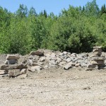 Students have erected two inukshuk in front of a rock wall at the pit
