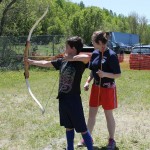 Colin Walton of Centreville draws his bow as Jessica Booker, the youth rep of Twin Rivers Archery Club, offers a few pointers
