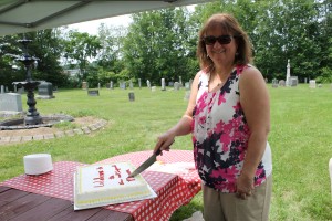 Historical Society President Louise Lennon cuts the celebratory cake